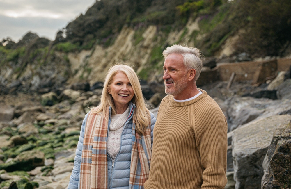 couple in winter clothes walking near beach