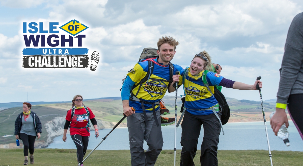 walkers celebrating with countryside and coastline in the background