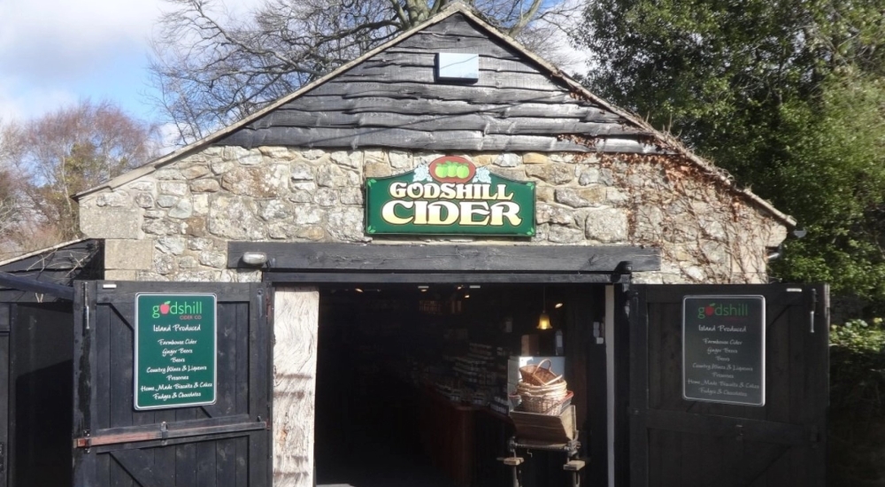 exterior of a stone barn with 'godshill cider' sign 