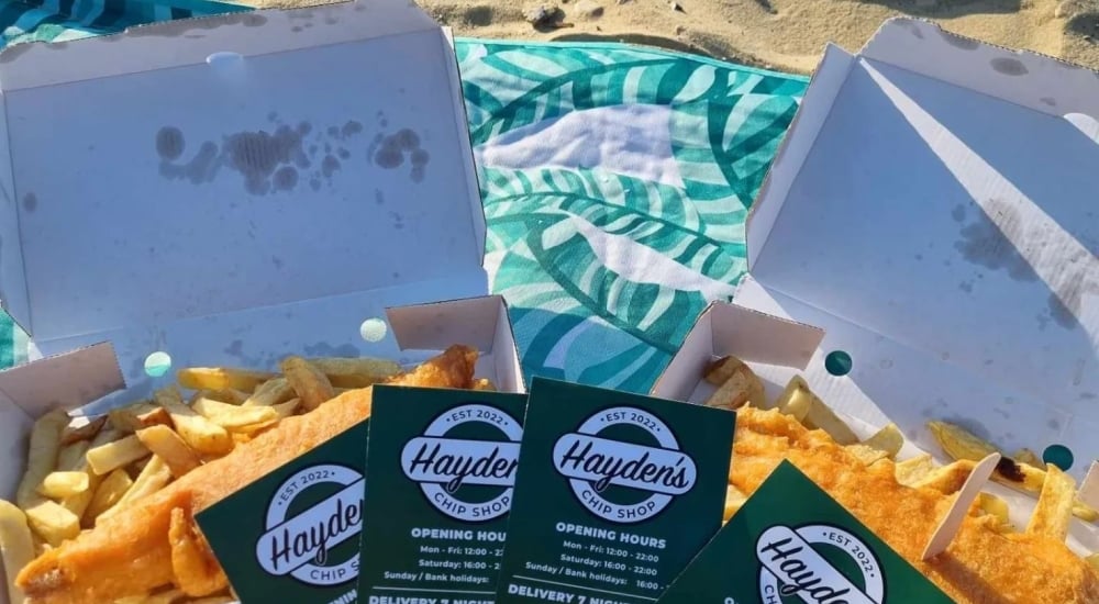 portions of fish and chips on the beach