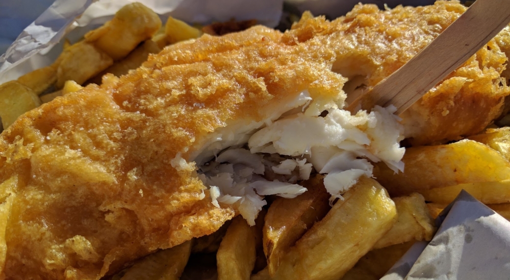 battered fish on top of golden chips