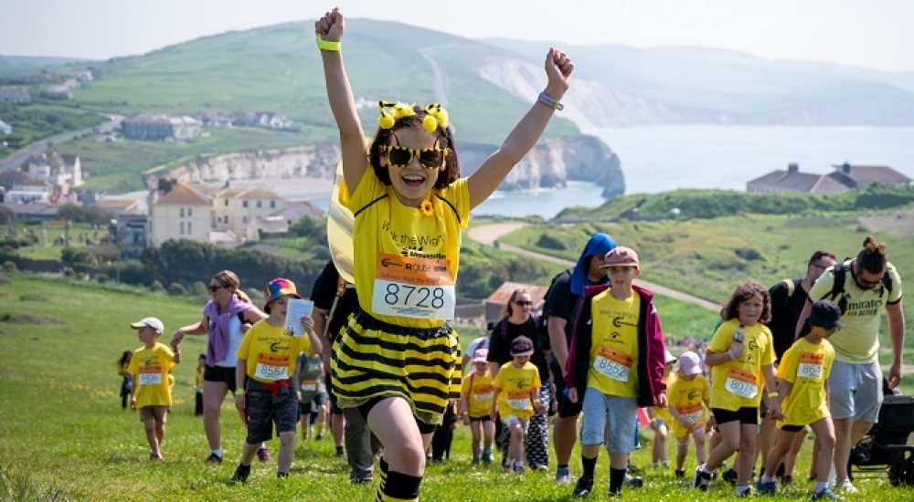 little girl in bee costume cheering